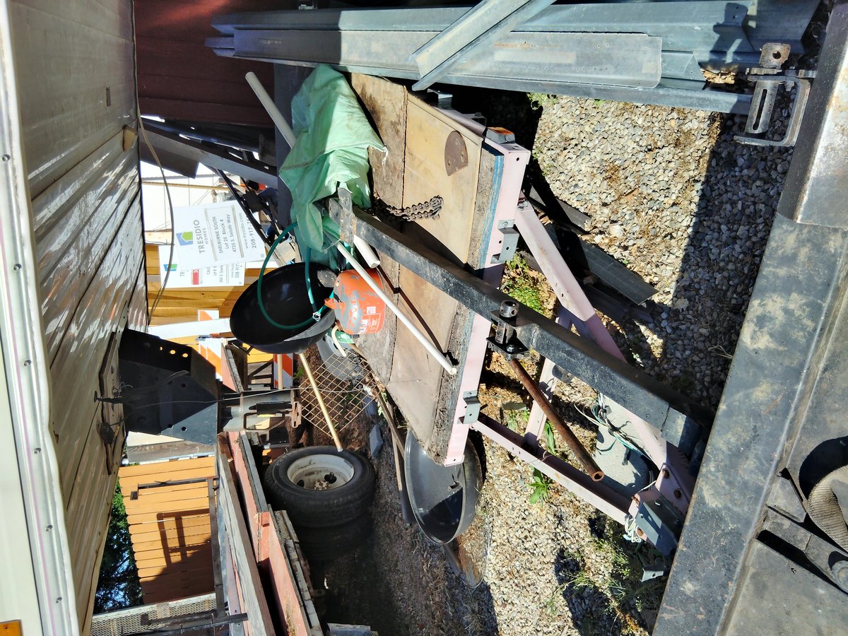 Old metal trailer with worn wooden deck and tools